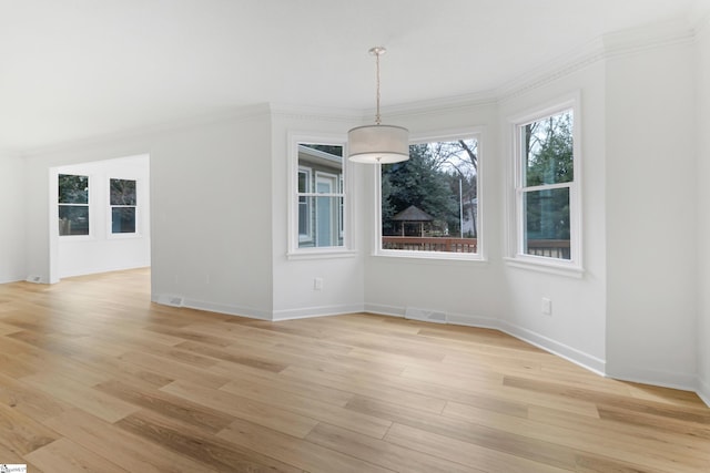 unfurnished dining area with baseboards, light wood-style flooring, visible vents, and crown molding