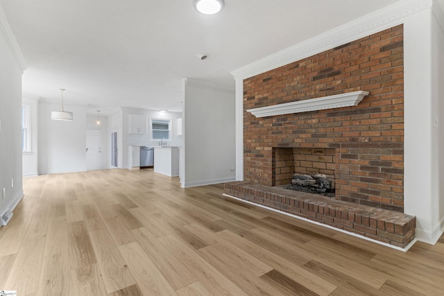 unfurnished living room featuring light wood finished floors, visible vents, a fireplace, and ornamental molding