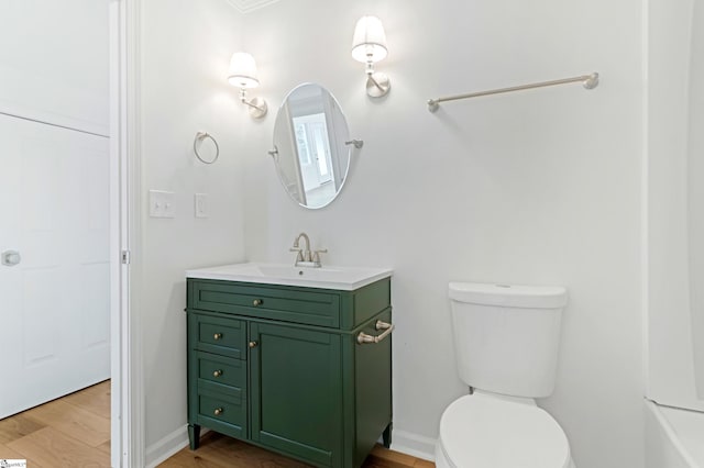 bathroom featuring vanity, wood finished floors, toilet, and baseboards