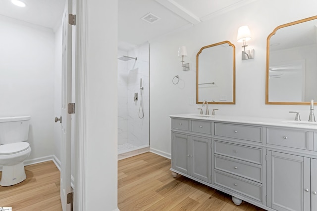 full bathroom with a marble finish shower, double vanity, visible vents, a sink, and wood finished floors