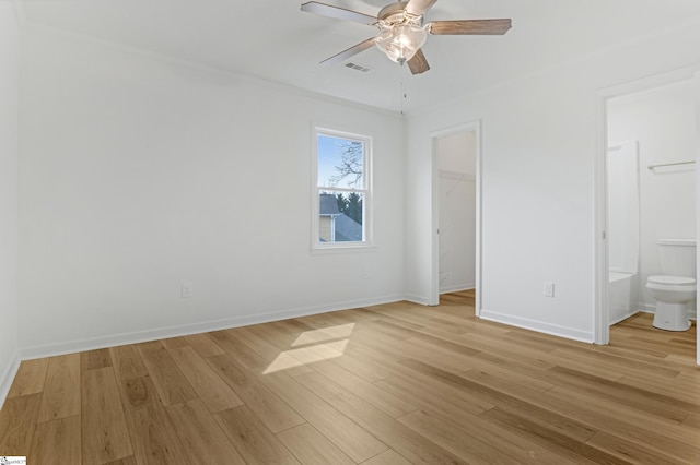 unfurnished bedroom featuring visible vents, baseboards, a closet, light wood-type flooring, and a walk in closet