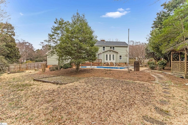 back of house featuring a fenced in pool, french doors, fence, and a chimney