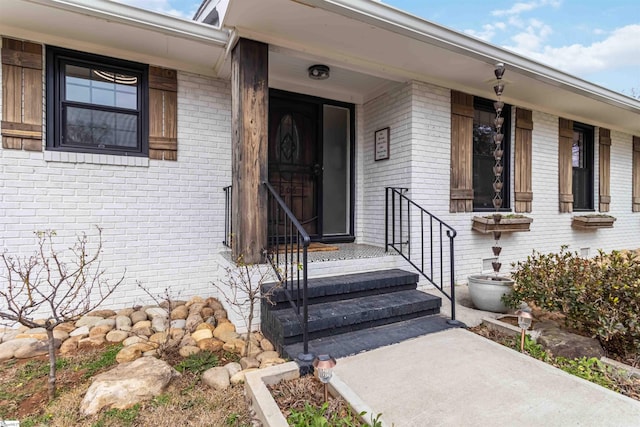 view of exterior entry featuring brick siding