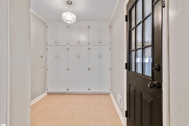 interior space featuring baseboards, light tile patterned floors, a wealth of natural light, and crown molding