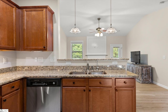 kitchen featuring stainless steel dishwasher, brown cabinetry, a sink, and light stone countertops