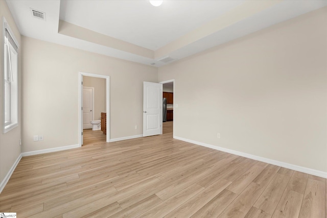 unfurnished bedroom with light wood-type flooring, visible vents, and baseboards