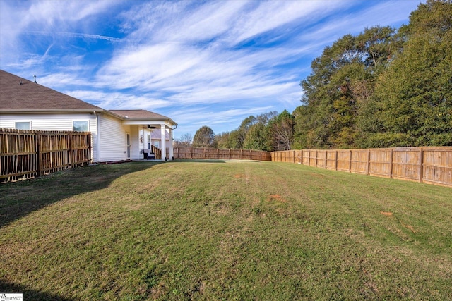 view of yard featuring a fenced backyard and a ceiling fan