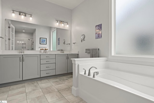 bathroom featuring double vanity, a shower stall, a bath, and a sink