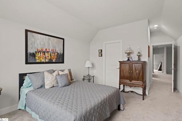 bedroom with light colored carpet, baseboards, and lofted ceiling