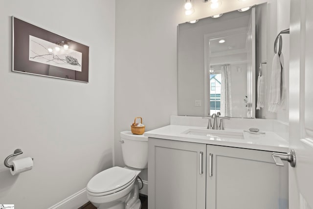 bathroom featuring vanity, toilet, and baseboards