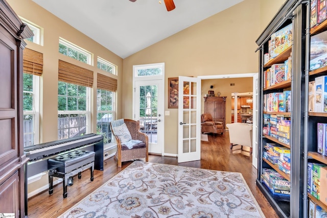 living area with high vaulted ceiling, a ceiling fan, wood finished floors, and french doors