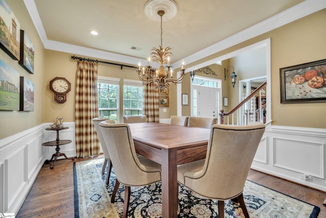 dining room with visible vents, wood finished floors, a wealth of natural light, and crown molding