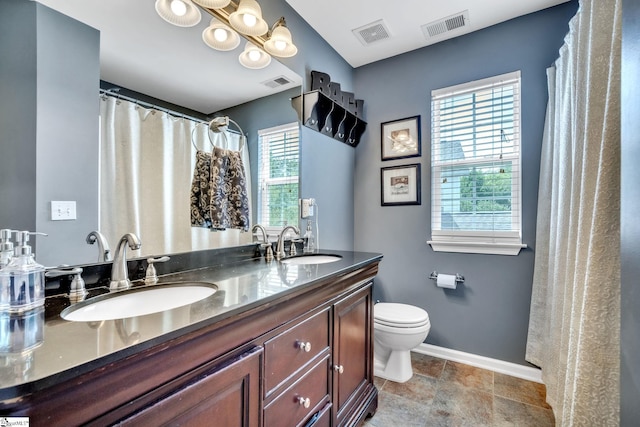 bathroom featuring toilet, a sink, and visible vents