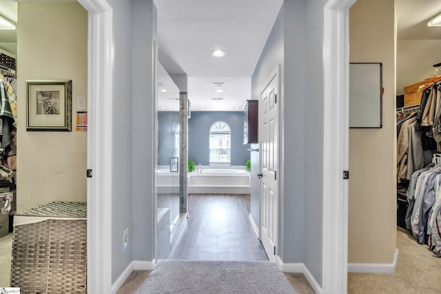 corridor with light carpet, recessed lighting, and baseboards