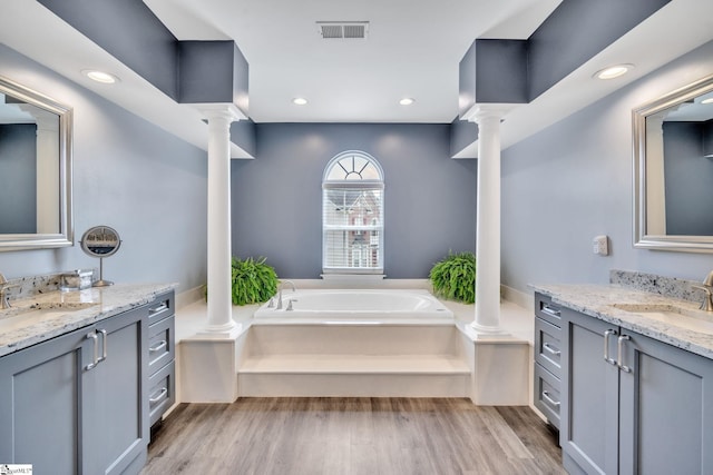 full bathroom with visible vents, wood finished floors, a sink, and decorative columns