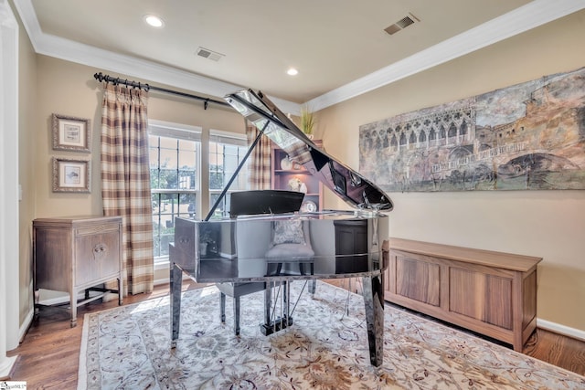 sitting room featuring ornamental molding, visible vents, and wood finished floors