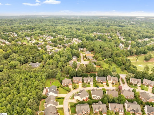 drone / aerial view featuring a residential view and a wooded view