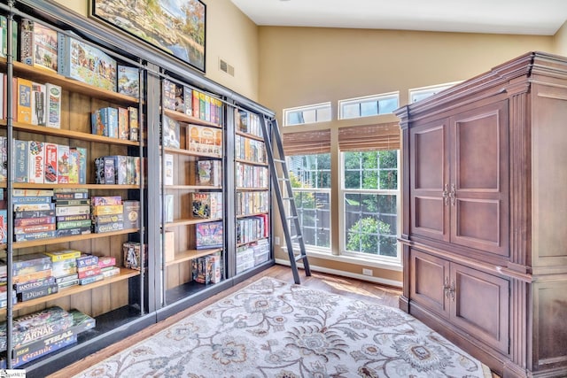 unfurnished room with lofted ceiling, visible vents, and wood finished floors