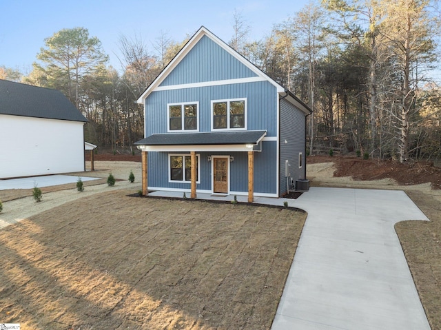 view of front of property with central AC unit, a porch, and a front yard