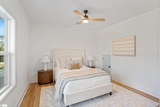 bedroom featuring a ceiling fan, baseboards, and wood finished floors