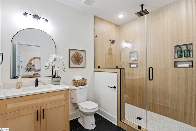 bathroom with toilet, vanity, visible vents, tile patterned floors, and a stall shower