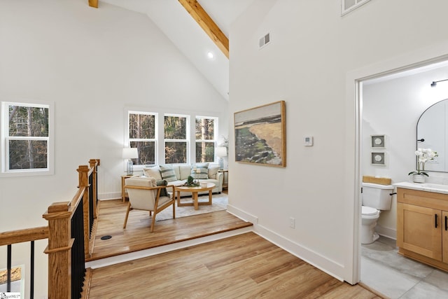 home office with high vaulted ceiling, beamed ceiling, light wood-style flooring, and baseboards