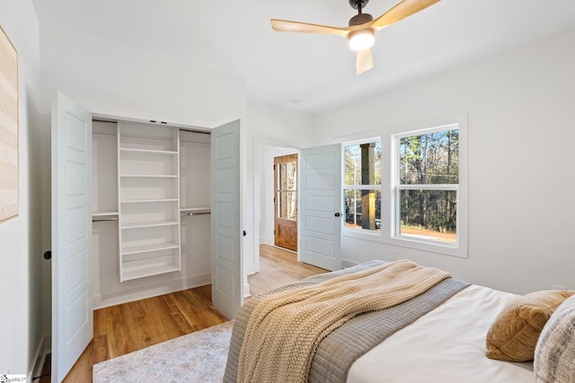 bedroom with light wood-type flooring, baseboards, a ceiling fan, and a closet