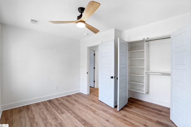 unfurnished bedroom featuring baseboards, a closet, visible vents, and light wood-style floors