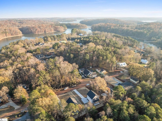 birds eye view of property with a water view and a wooded view