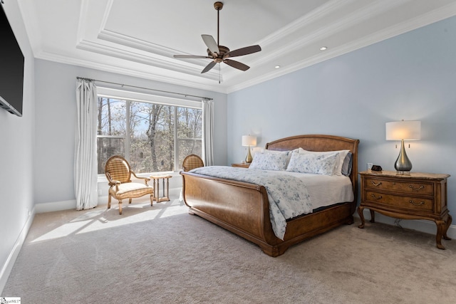 carpeted bedroom featuring a tray ceiling, crown molding, baseboards, and ceiling fan