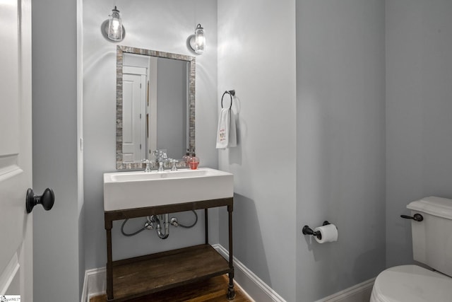 half bathroom with toilet and baseboards