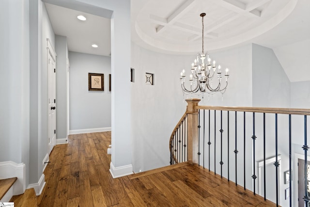 hall featuring baseboards, coffered ceiling, wood finished floors, an upstairs landing, and recessed lighting