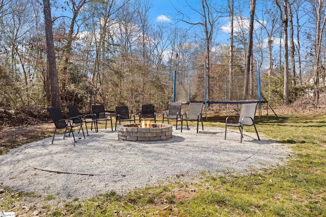 exterior space featuring a trampoline and a fire pit