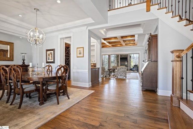 dining space with dark wood-style flooring, crown molding, and stairs