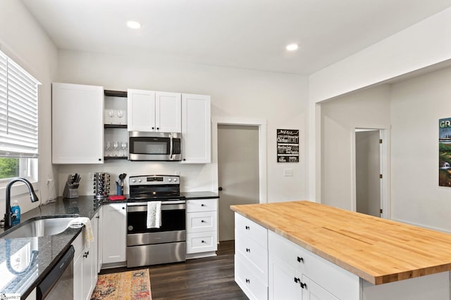 kitchen with dark wood finished floors, open shelves, stainless steel appliances, white cabinetry, and a sink