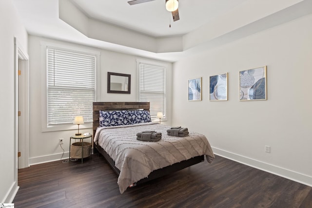 bedroom with dark wood-type flooring, ceiling fan, and baseboards