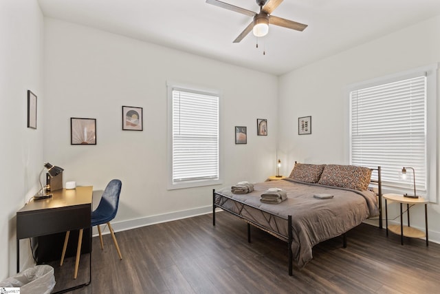 bedroom with dark wood finished floors, a ceiling fan, and baseboards