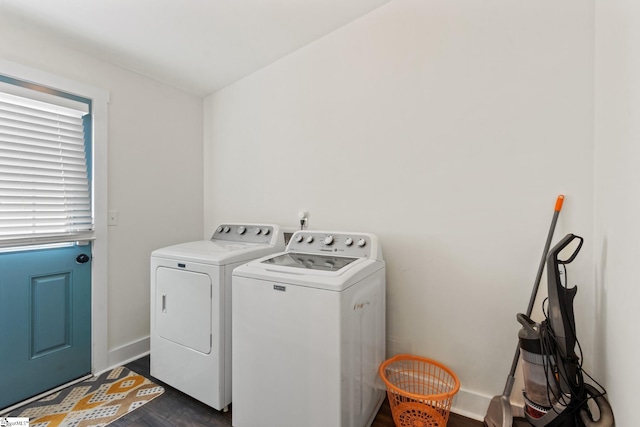 laundry room featuring laundry area, baseboards, washer and clothes dryer, and dark wood-type flooring