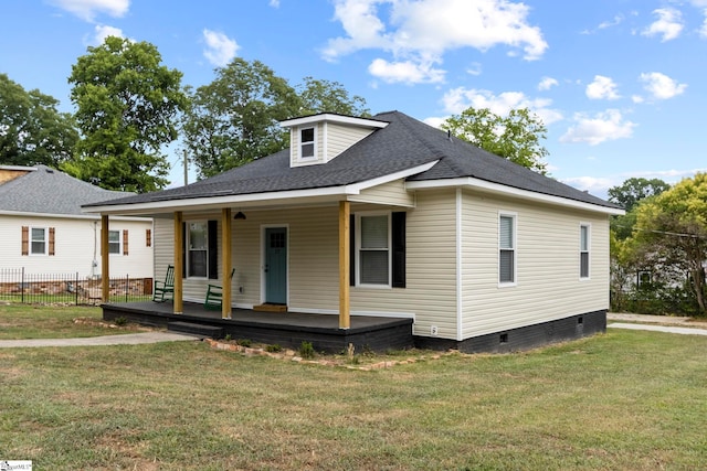 view of front of home with covered porch, roof with shingles, a front lawn, and crawl space