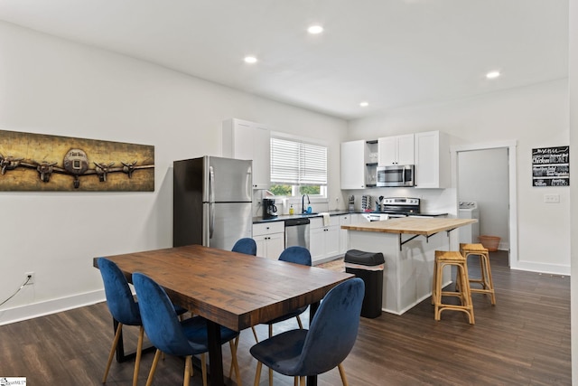 dining area featuring baseboards, washer / clothes dryer, dark wood-style flooring, and recessed lighting