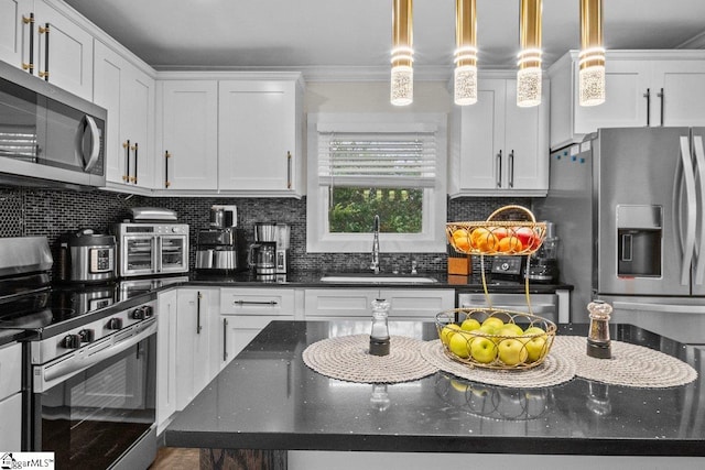 kitchen with backsplash, white cabinetry, stainless steel appliances, and a sink