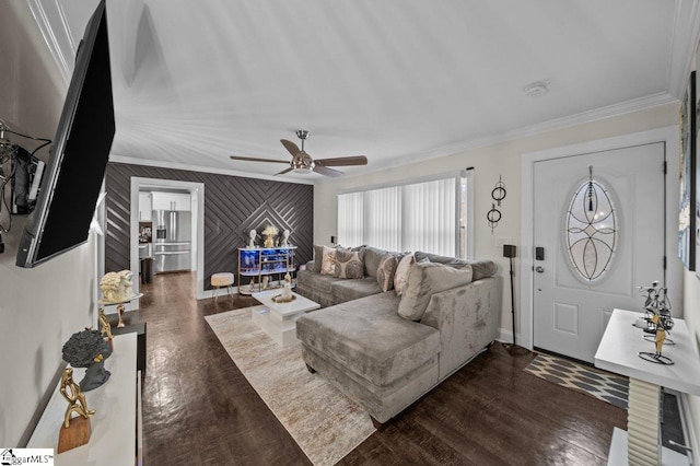 living room featuring baseboards, ceiling fan, dark wood finished floors, and crown molding