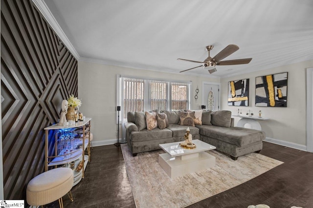 living area featuring dark wood-style floors, baseboards, ornamental molding, and ceiling fan