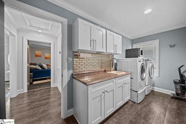 laundry area with attic access, crown molding, a sink, and separate washer and dryer