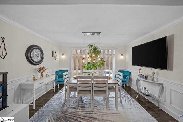 dining area with a chandelier, a decorative wall, a wainscoted wall, wood finished floors, and crown molding