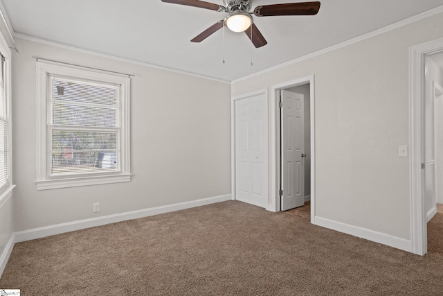 unfurnished bedroom with ornamental molding, carpet, a ceiling fan, and baseboards