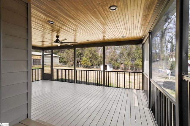 unfurnished sunroom featuring wood ceiling and ceiling fan