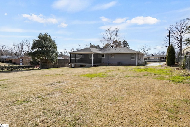 exterior space featuring a sunroom, fence, and a lawn