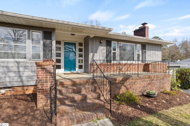 view of front of home featuring covered porch and a chimney