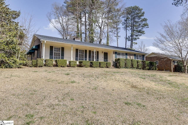 ranch-style house featuring a front yard, covered porch, a chimney, and stucco siding